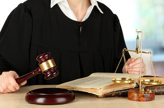 bigstock-Judge-sitting-at-table-during--42511381.jpg